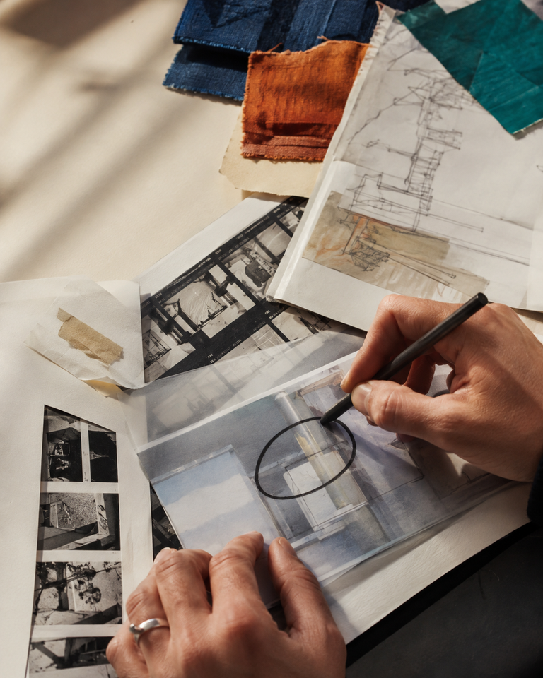 Hands annotating material studies, sketches, and process photography